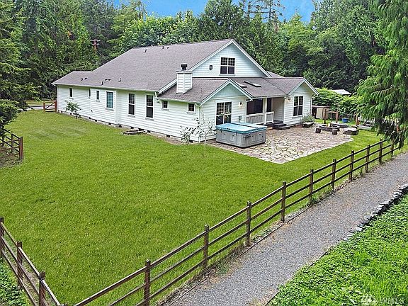 Fully fenced property with hot tub, fire pit, covered deck, raised garden space and attached 2 car garage and detached shop/3 car garage