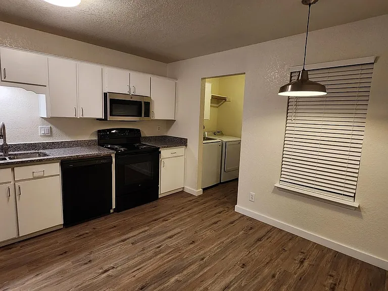 Lots of lighting in the kitchen with a window to the balcony and 2" faux wood blinds.