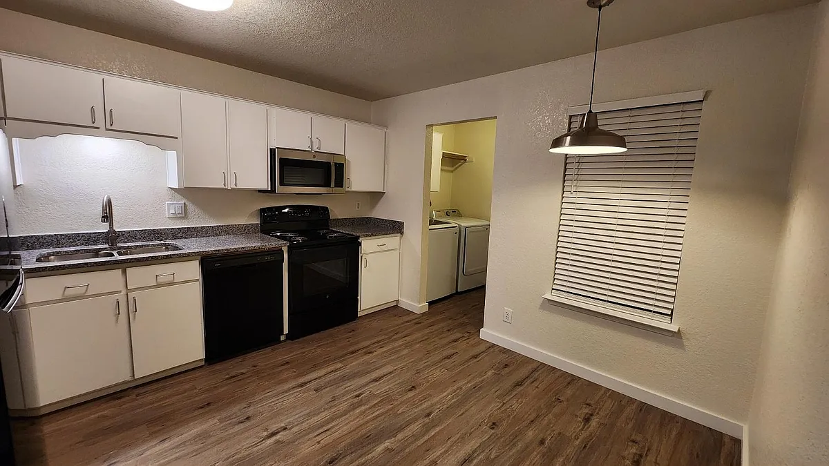 Lots of lighting in the kitchen with a window to the balcony and 2" faux wood blinds. - 1110 Circle M Dr #B