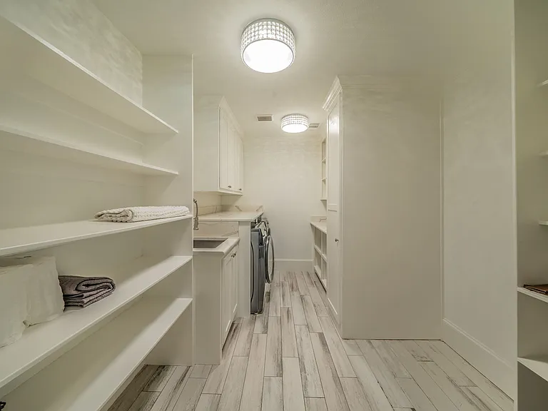 Spacious Modern Laundry Room with Washer, Dryer & Ample Storage Shelves