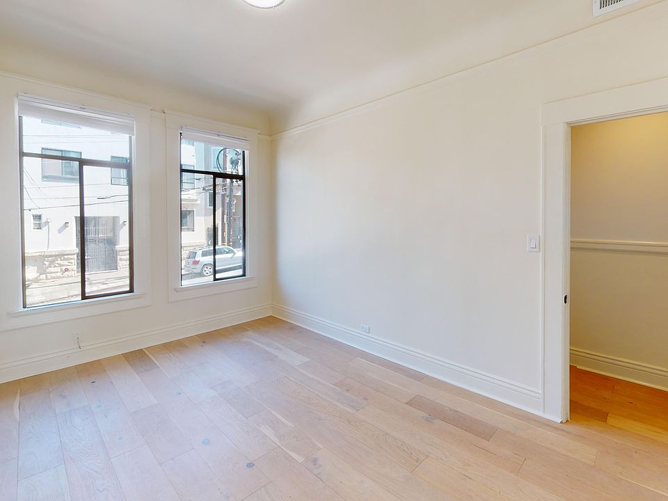 Spacious room with wood-like flooring and a large window offering natural light