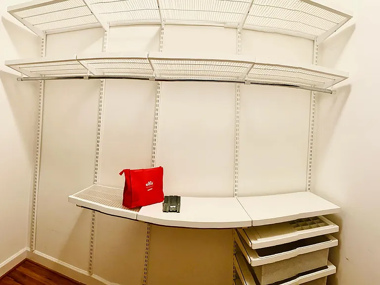 Full view of the Elfa system - two tall shelves at top that run the length of the wall, space on left for long-hanging items, two levels of short-hanging storage, jewelry drawer w/organizer, and three pull-out drawers for stashing your items.