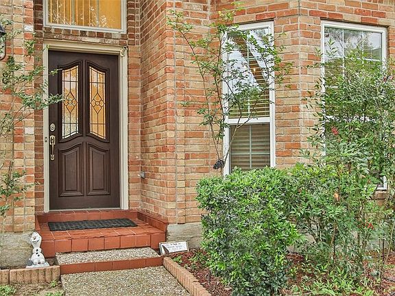 When your guests arrive at your wood front door with its elegant leaded glass panels, they are protected from the elements by the high arch covering the front step.