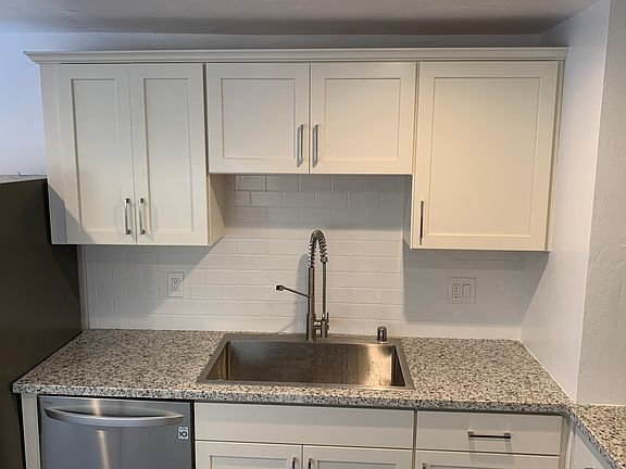 Granite counters, tile backsplash, sink, garbage disposal