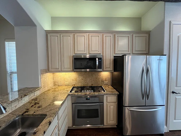 Beautiful kitchen with designer cabinets, high-end appliances, and refrigerator