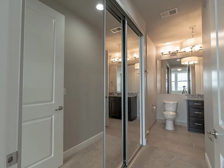 Bathroom Entrance and Mirrored Closet Space