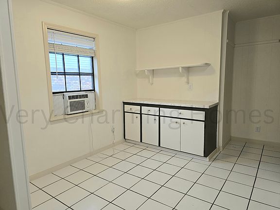 Extra counter and storage space and dining area in the kitchen. The unit does have central air but the window unit remains to cool the kitchen extra while cooking.