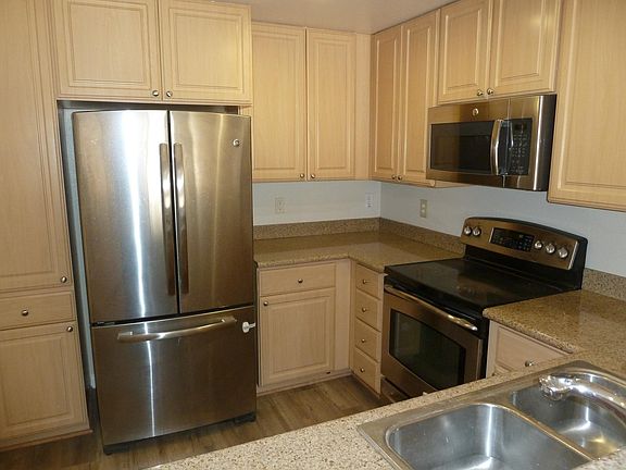 Granite counters, Stainless steel appliances & luxury vinyl plank flooring in kitchen