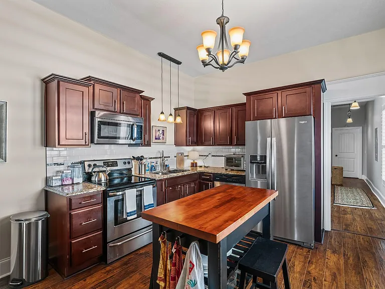 Modern and functional, the kitchen is equipped with granite countertops, stainless steel appliances, and ample cabinetry.