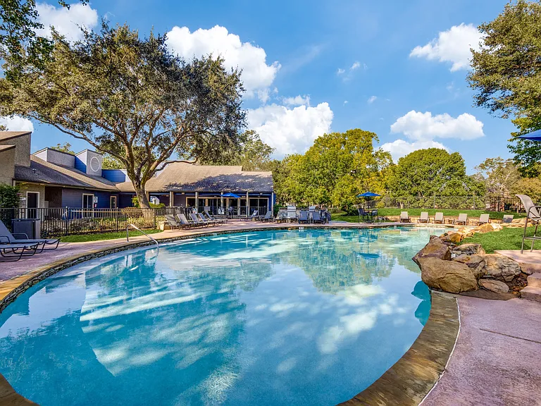 Pool surrounded by trees and seating areas