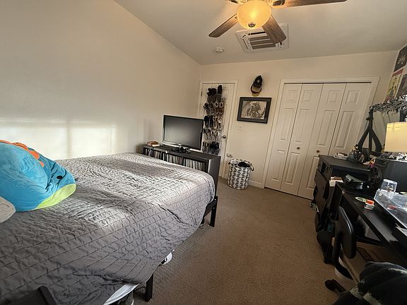 12x11' bedroom with previous tenant's furnishings (bedroom avail 8/15/2026), view of closet doors, closed bedroom door, ceiling fan, and mini split ceiling vent