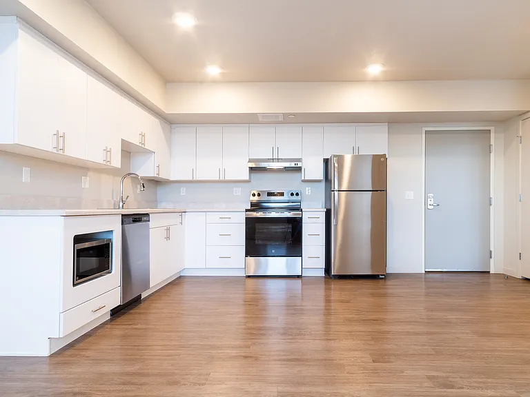 Kitchen with abundant cabinet space and adjacent to living room. One-Bedroom unit.