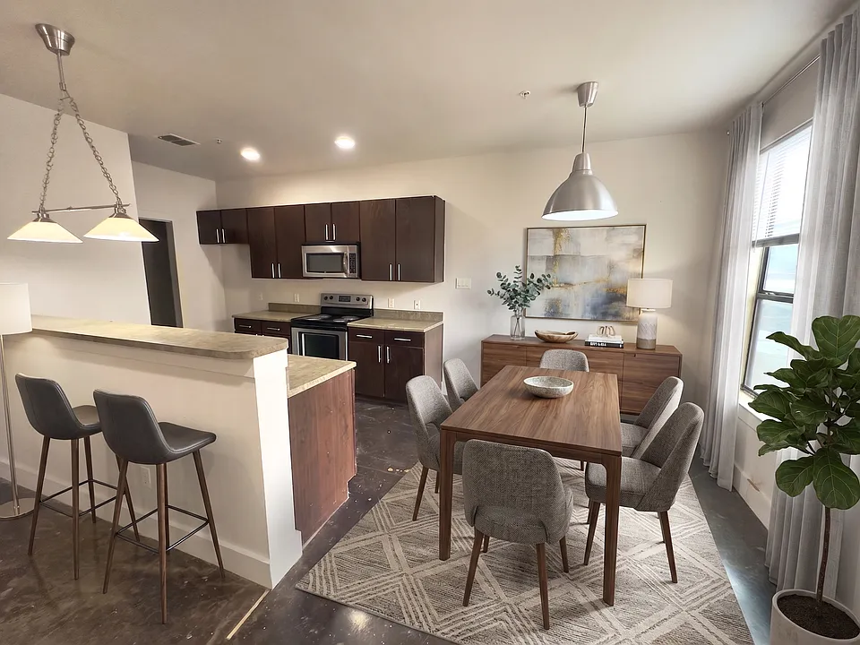 MODERN KITCHEN WITH STAINLESS STEEL APPLIANCES AND OPEN CONCEPT TO DINING AREA