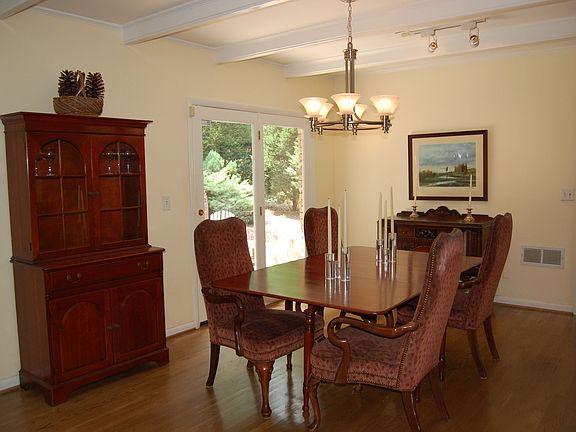 Dining area has brick fireplace opening to patio with outdoor brick fireplace.