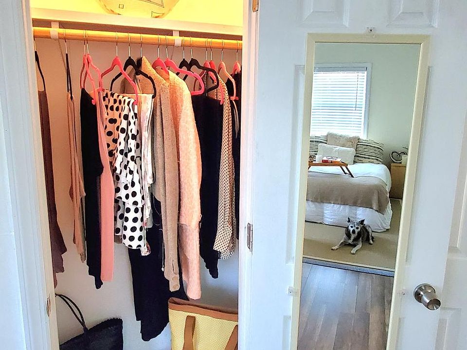 Closet with overhead lighting, shelving and mirror attached to the closet door, for your convenience.