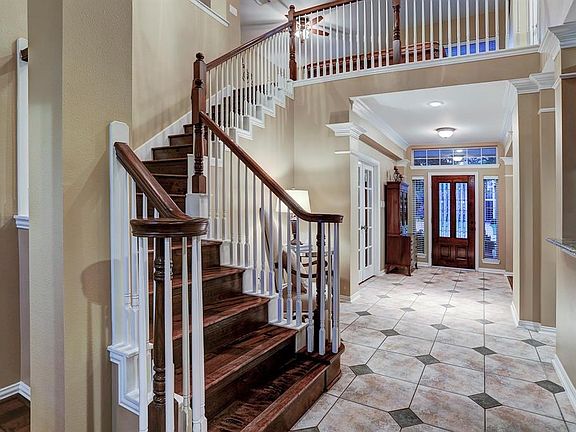 Sweeping hardwood staircase takes you to the game room.