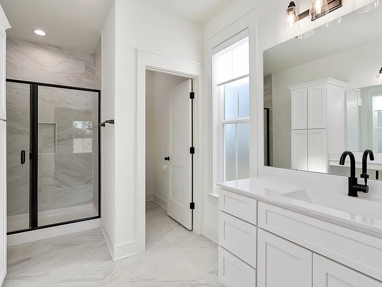 Master bathroom has a frosted window and window shade and a second sink and vanity.