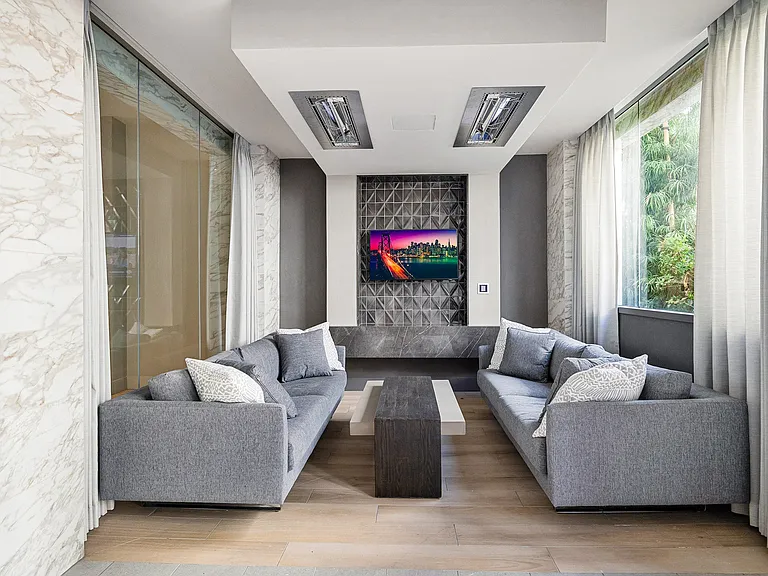Lounge with modern sofas, marble details, and wall-mounted TV