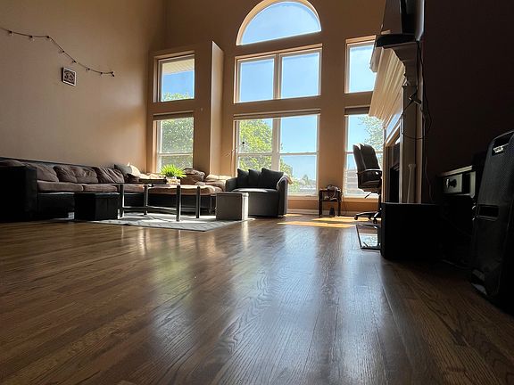 Living room on 1st floor with 30+ foot ceilings and tall east-facing windows flooding morning sunlight (pic 2 of 2)