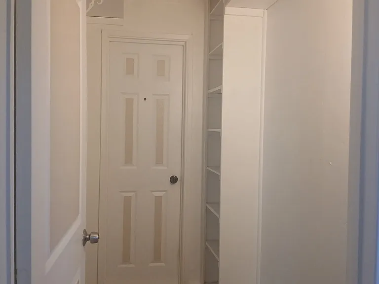 Hallway between both bedrooms, and door into the main house.