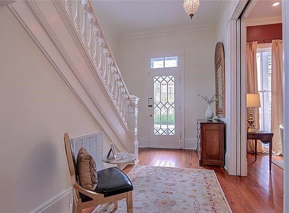ORNATE SPINDLES IN THE RAILING, WIDE BASEBOARDS, HI CEILINGS 11 FT UP AND DOWN, WOOD FLOORS. POCKET DOORS SEPARATING THE FOYER FROM THE FORMAL LIVING ROOM. CRYSTAL CHANDELIER.