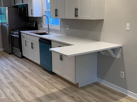 Kitchen with eat in quartz counter.