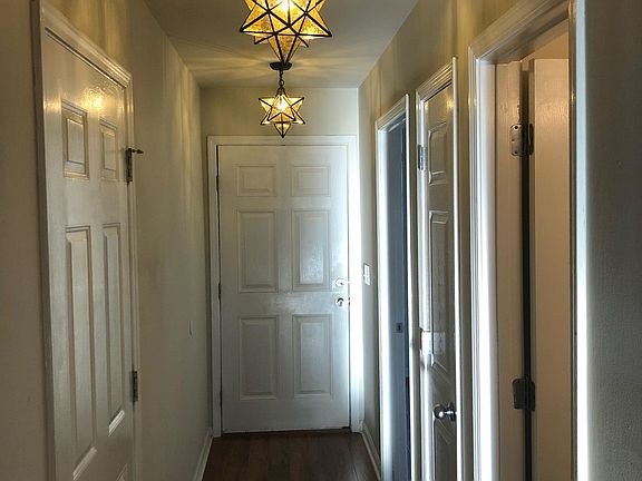 Entryway with Doors to Garage/Laundry, Front Bedroom, Hall Bathroom and Linen/Coat Closet