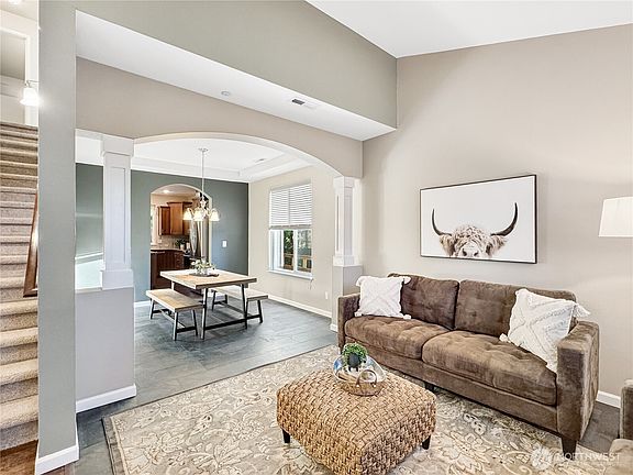 The great room leads into a formal dining room through a gorgeous archway.>