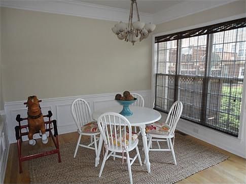Dining room with a bank of windows and wainscoting.