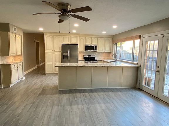 Nicely renovated kitchen with elegant granite counter tops, updated cabinetry, stylish backsplash, and ceiling lights.