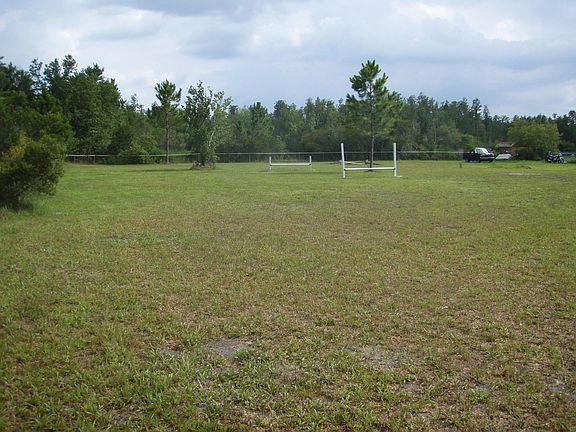 view of property from back left corner behind the house near the woods