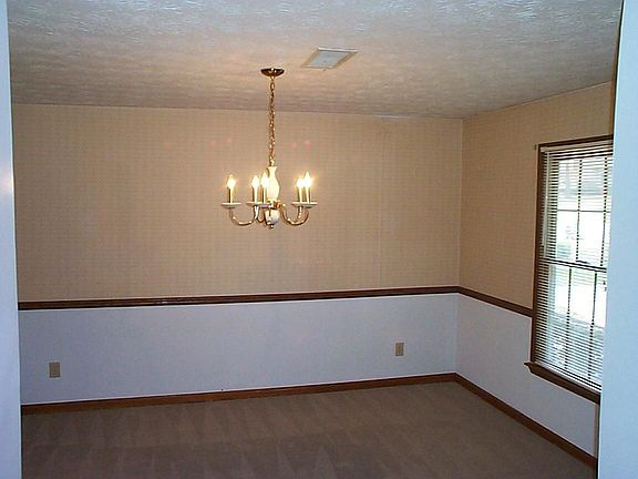 Big dining rom has extra trim and a nice chandelier.