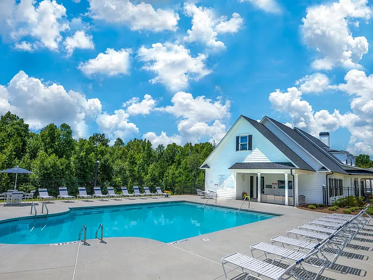 Pool off the backside of the Clubhouse that offers table seating with umbrellas.