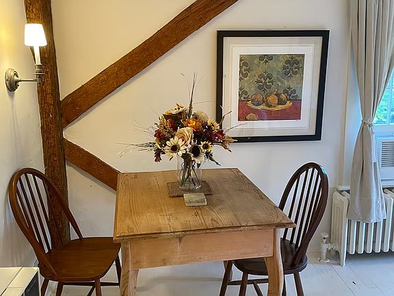 Your dining nook complete with a French pine table, Danish chairs, marble coasters and a bouquet that matches the framed print on the wall.