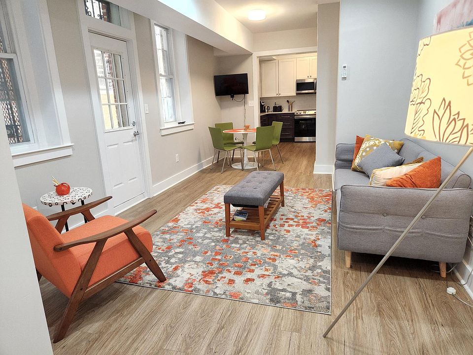 Living room area facing towards dining area, smart television and into kitchen. Full sized windows and high ceilings. Recently completely renovated and thoroughly cleaned between renters.