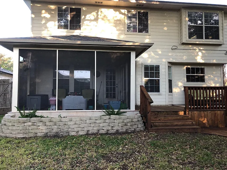 Screened in porch and deck with fire pit below.
