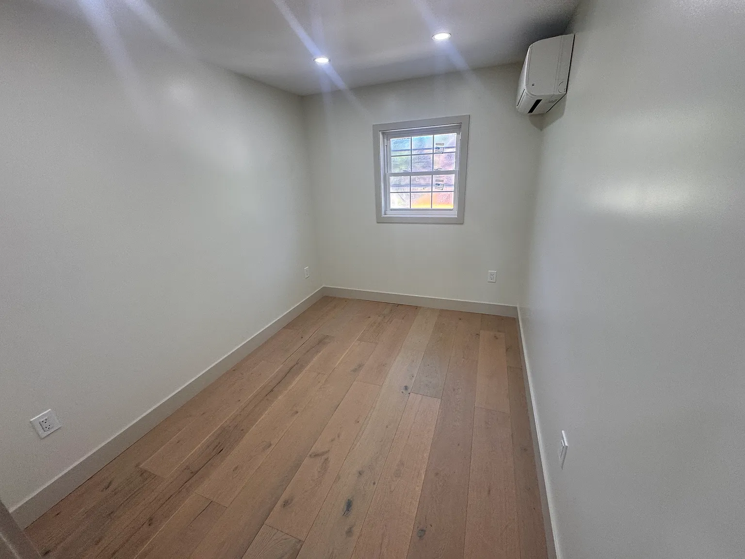 Bright second bedroom with hardwood floors, plenty of natural light and individual climate control
