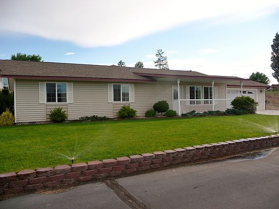 Well-maintained front yard has beautiful green grass and landscaping