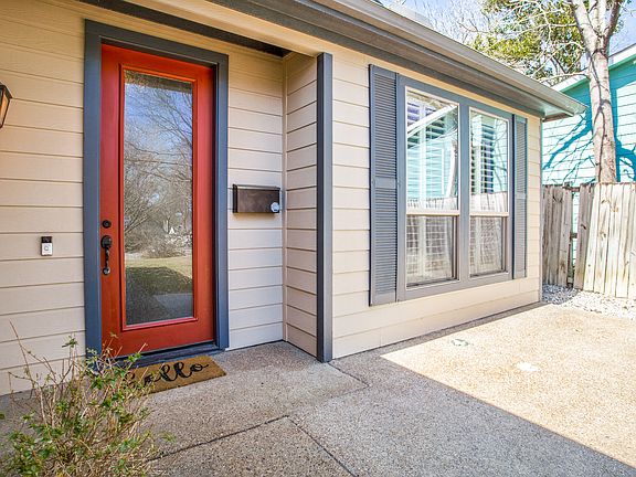 A closer look at the inviting front patio_perfect for morning coffee or an afternoon break, with classic shutters and a bold pop of color at the door.