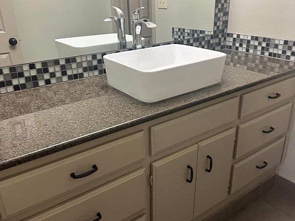 Master bath with granite counertops and vessel sink, two closets one is a walkin.