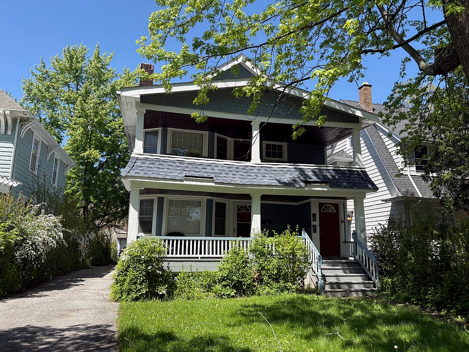 Front exterior of home showing second floor porch overlooking tree lined neighborhood