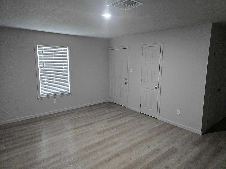 Large living room with new flooring and a storage closet