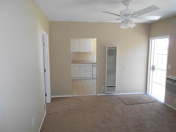 Living Room with a ceiling fan, a wall furnace and a wall air conditioner.