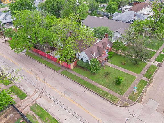 The property is situated on a corner lot, featuring a well-maintained lawn and mature trees