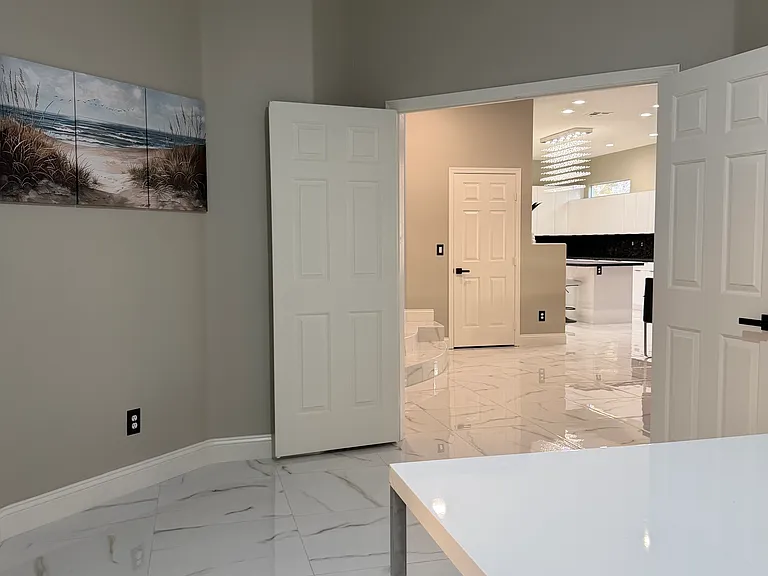 Private office with double doors, located just off the main living and dining area.