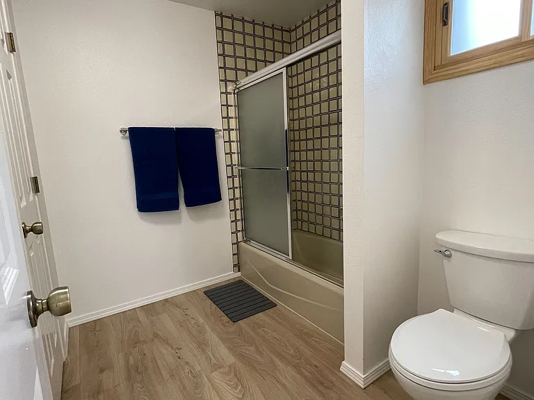 Primary Bathroom with beautiful hand-painted Mexican tile. Standard tub/shower, double-sink vanity area in separate area. Access to the under-stair closet.