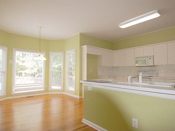 Light streams in through gorgeous bay window in breakfast room