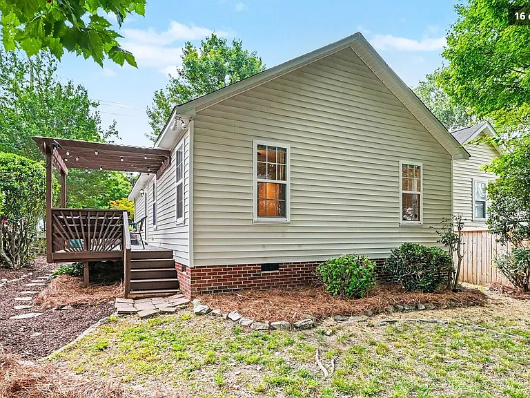 Fenced back yard with deck and driveway access.