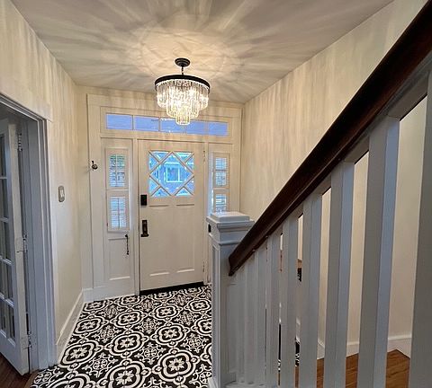 Entryway with brand new Italian tile, refinished hardwood stairs, and a brand new chandelier.