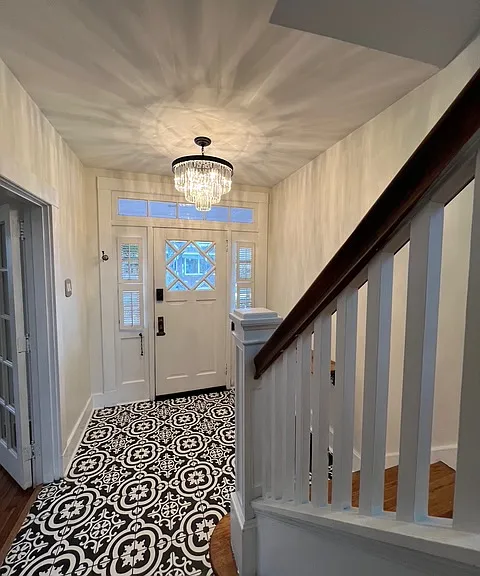 Entryway with brand new Italian tile, refinished hardwood stairs, and a brand new chandelier.